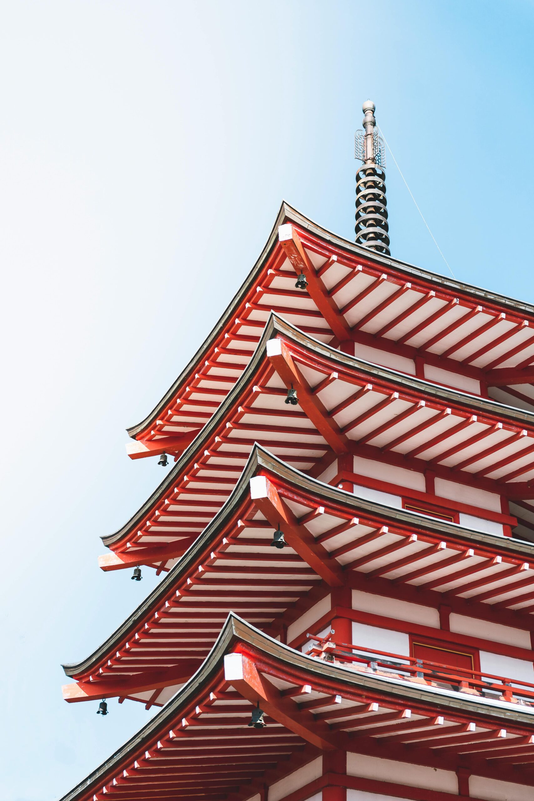 A stunning low-angle view of a traditional Japanese pagoda with intricate red and white architecture.